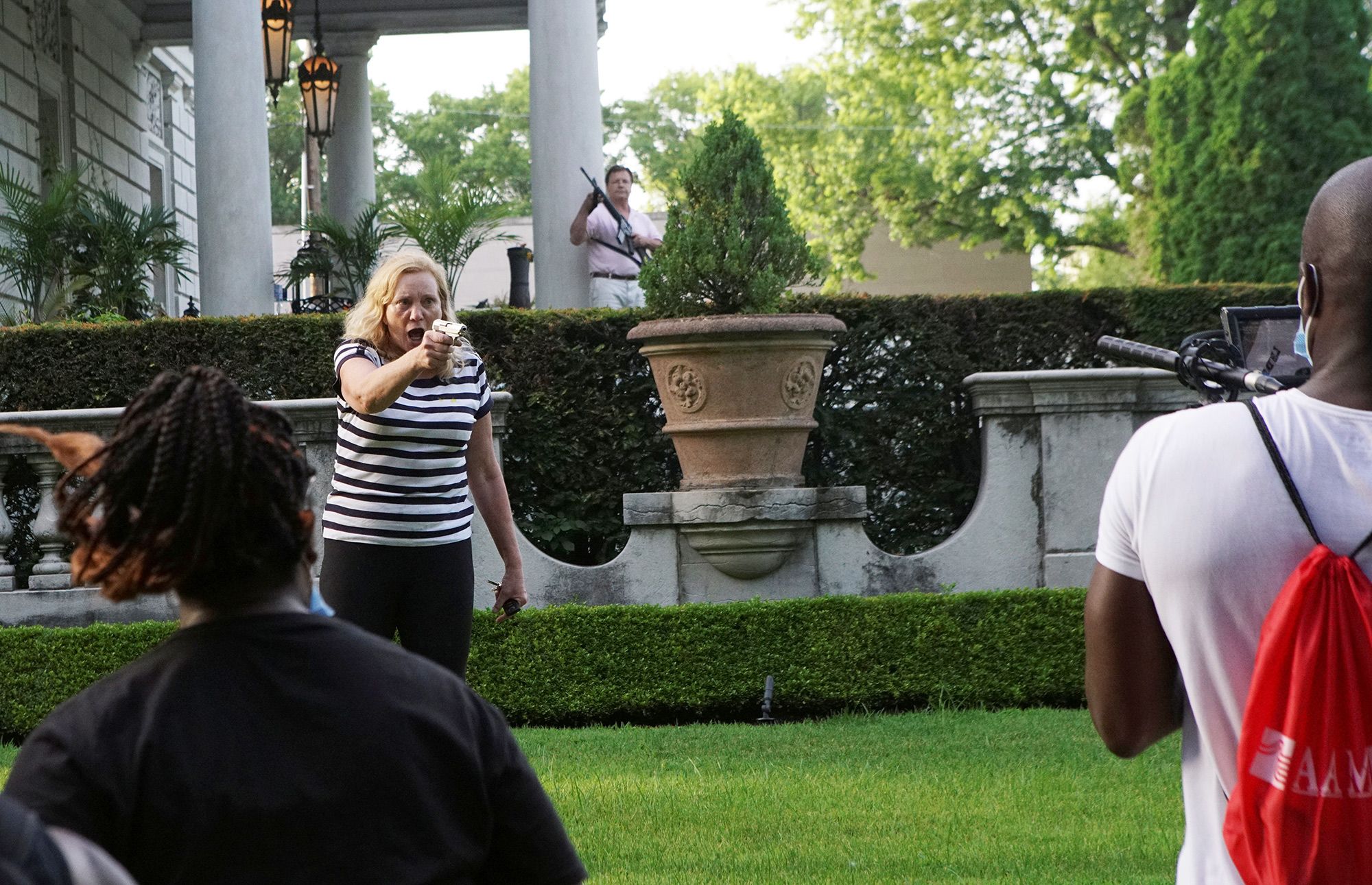 A couple draws their firearms on protesters as they enter their neighborhood during a protest against police brutality in St. Louis on June 28.