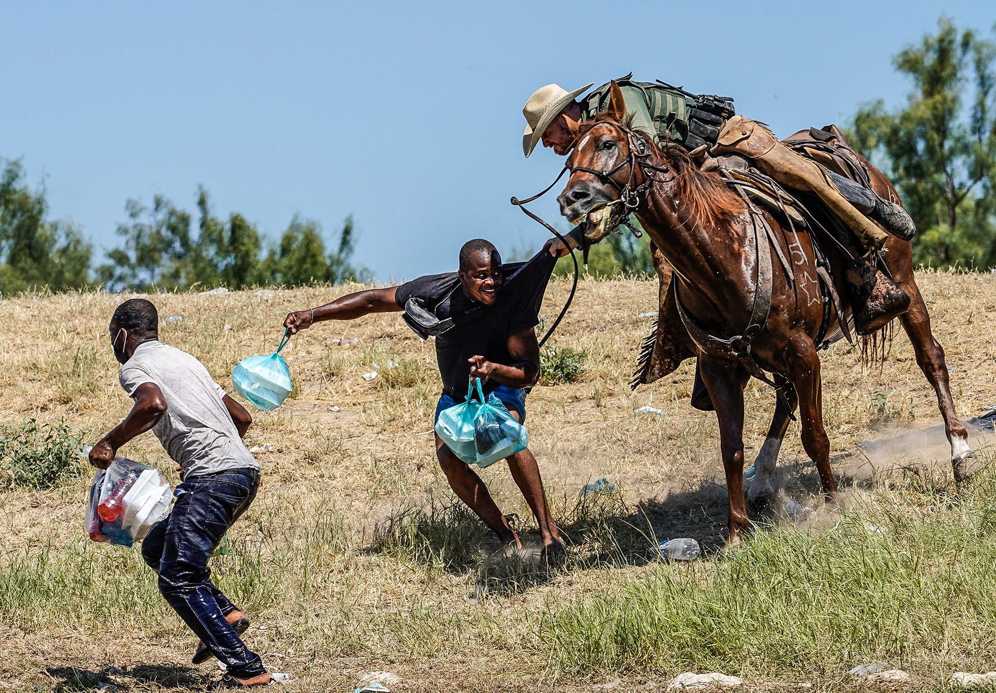A U.S. Border Patrol agent on horseback tries to stop a Haitian migrant from entering an encampment on the banks of the Rio Grande in Del Rio, Texas, on Sept. 19.