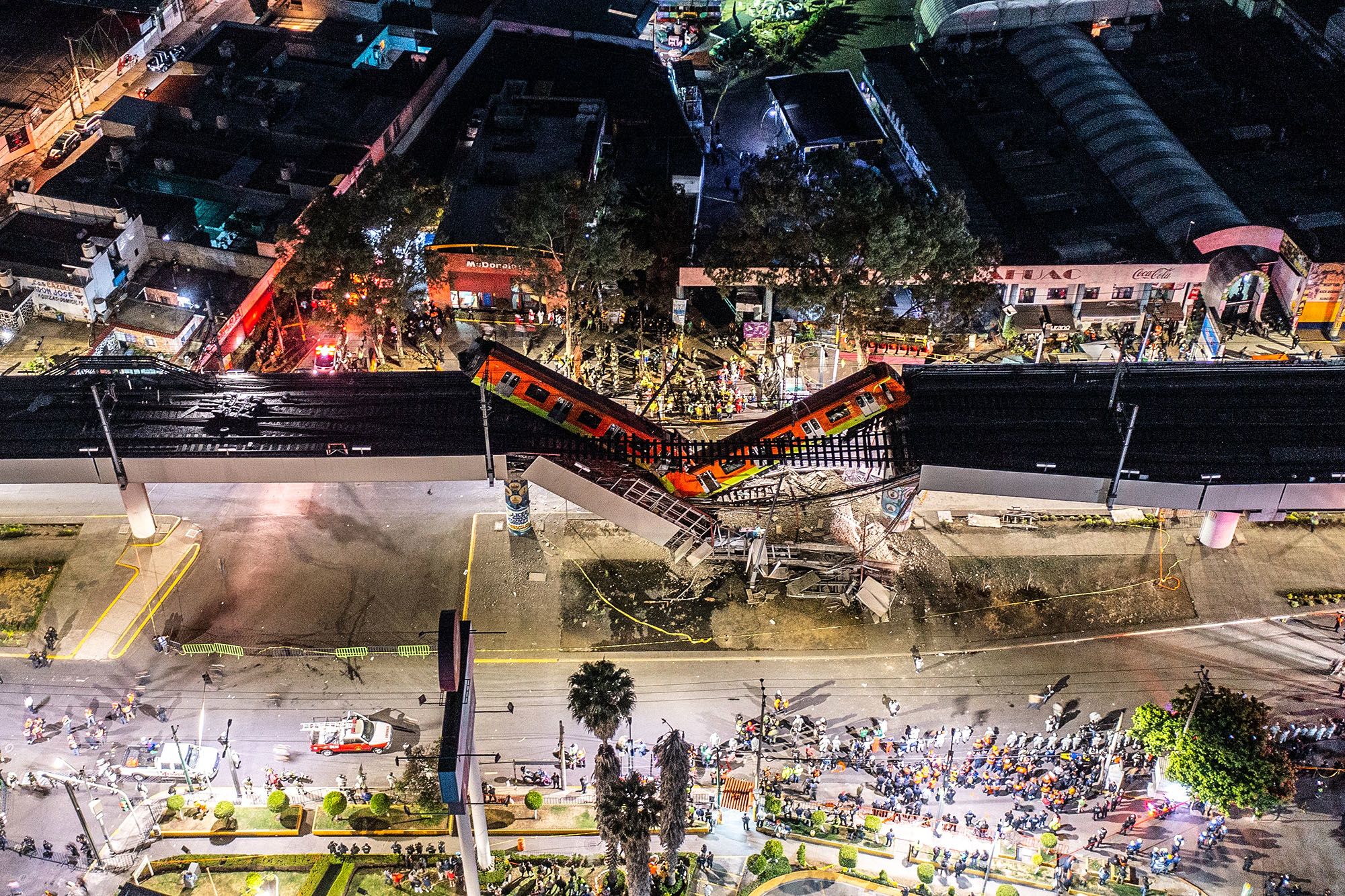 Train cars hang from an overpass in Mexico City on May 3. The overpass collapsed onto a busy road below, killing more than 20 people.