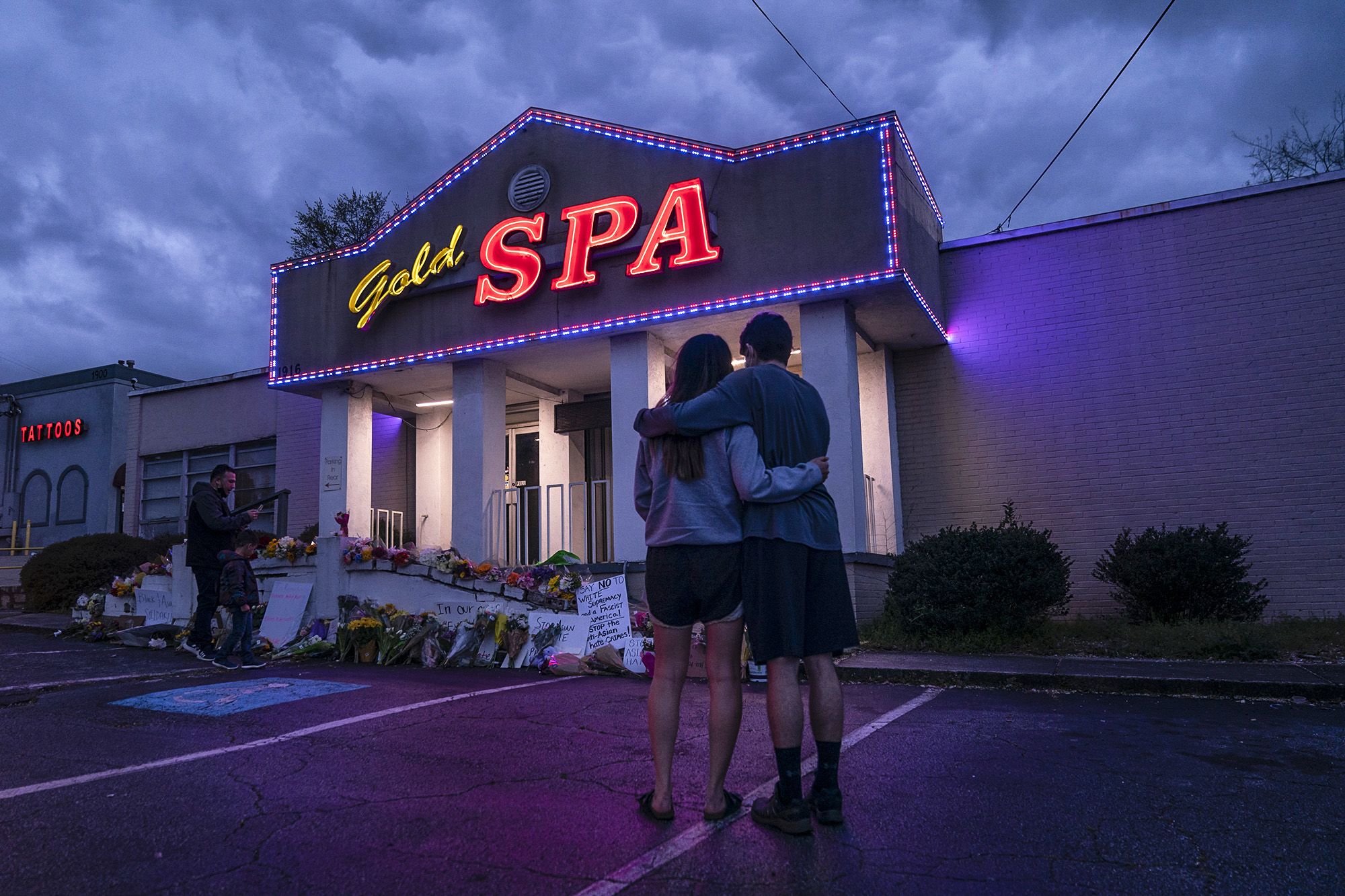 Graham Bloomsmith and Cynthia Shi hold each other outside Gold Spa where three women were shot and killed on March 18 in Atlanta.