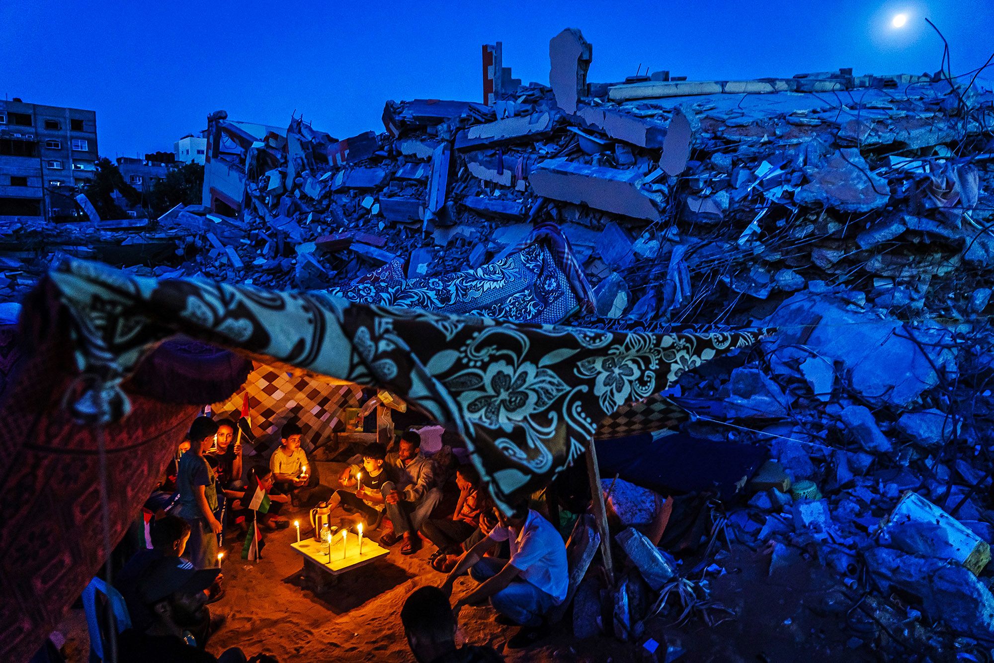 Palestinian children and family members attend a candlelight vigil to condemn the killing of children and civilians in Gaza City on May 25.