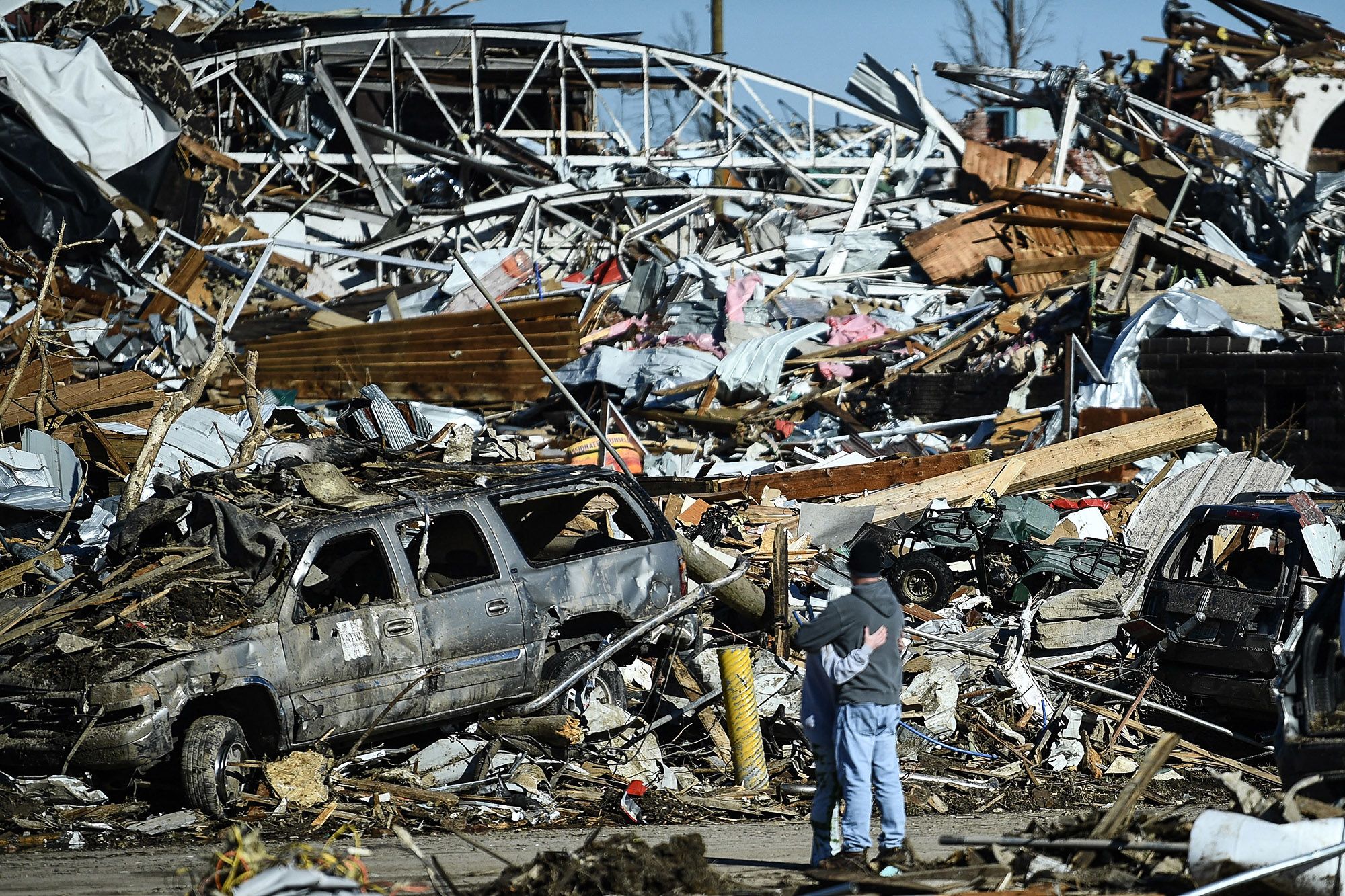 A couple embrace as they survey tornado damage on Dec. 12 in Mayfield, Ky