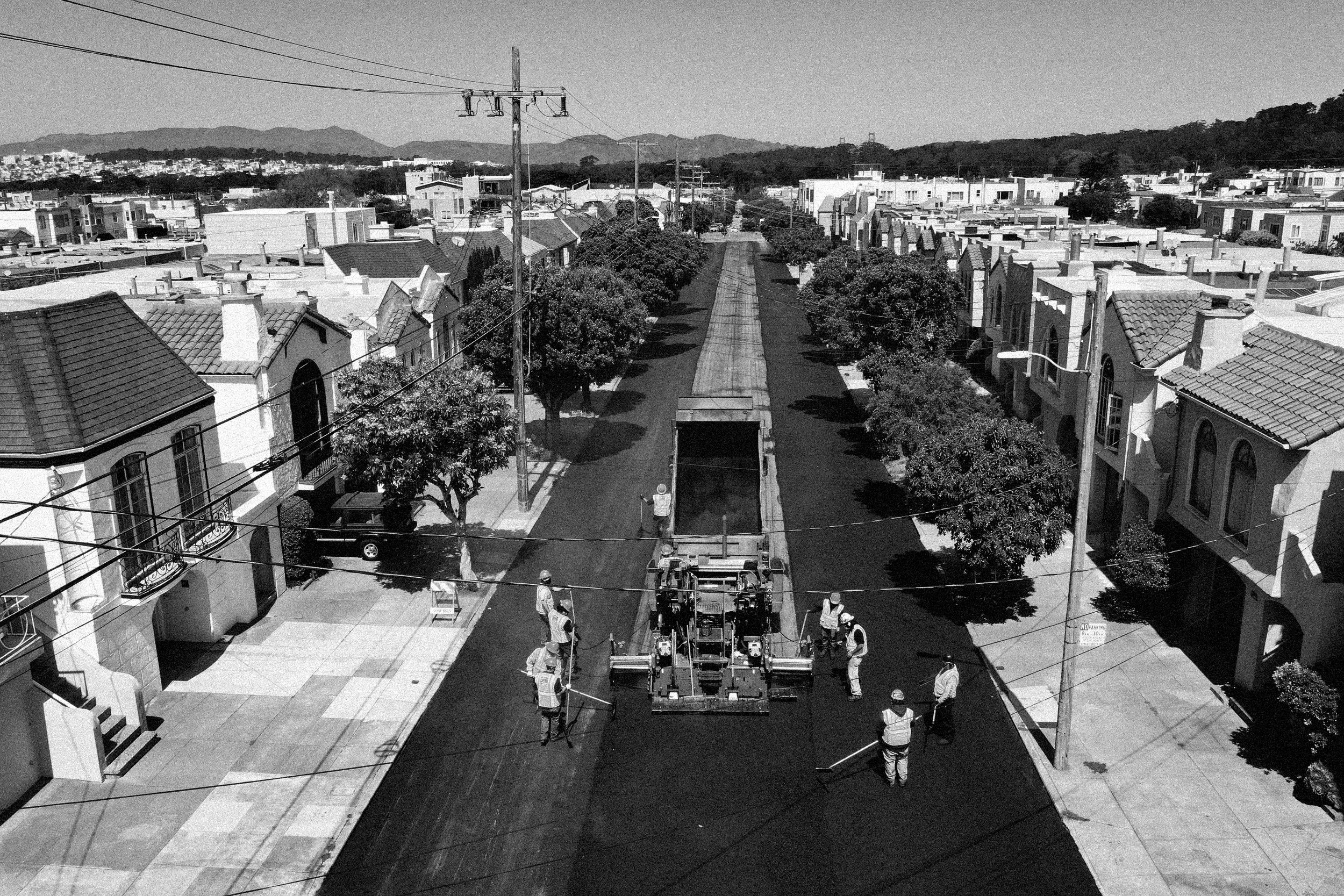 Workers with the San Francisco Department of Public Works repave a section of 24th Avenue on April 08, 2021, in San Francisco.
