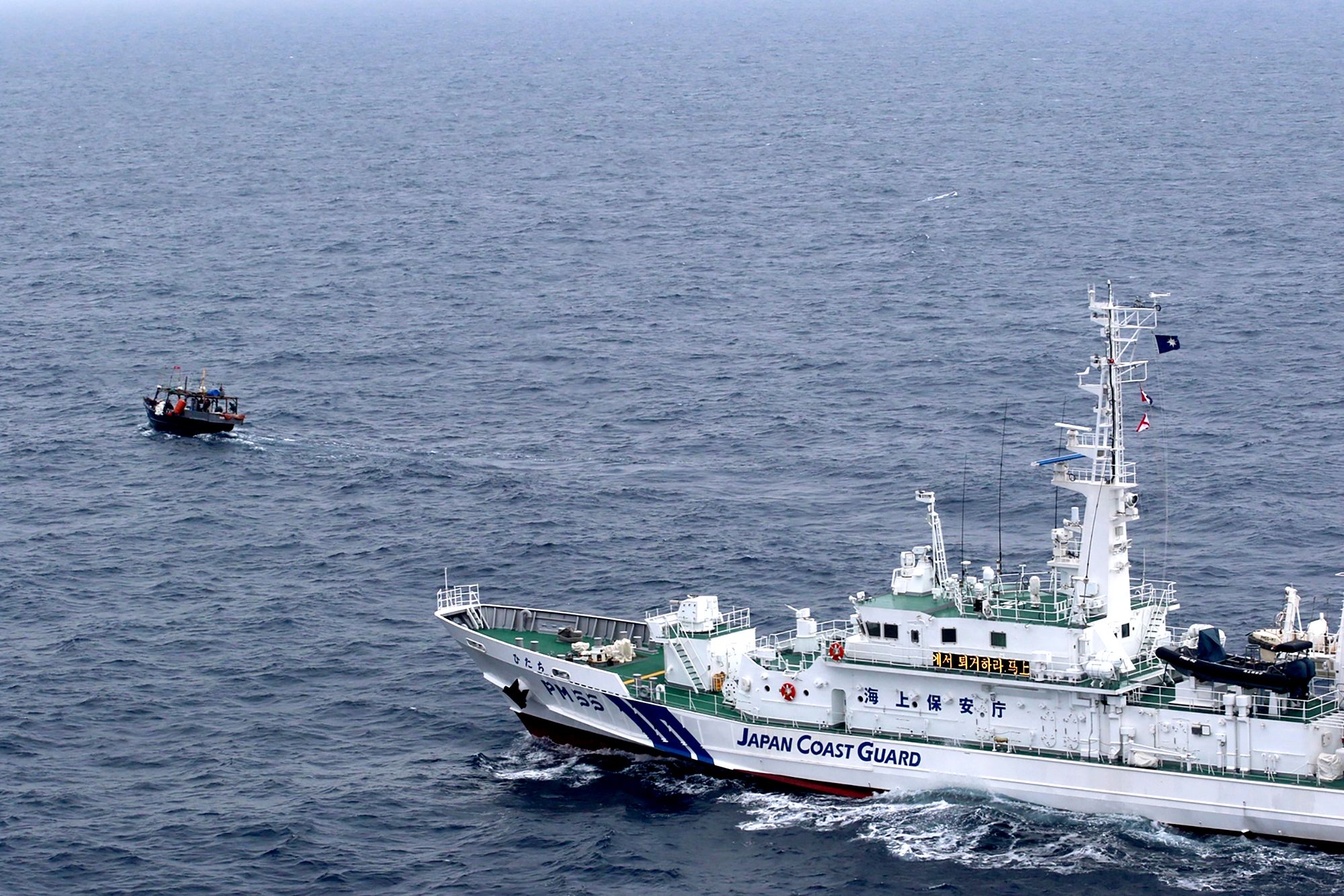 A Japanese Coast Guard patrol vessel approaches a North Korean fishing boat to warn them to leave the waters near Yamatotai, Japan in late May 2019.