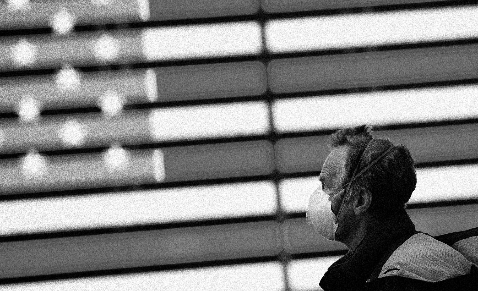 A man wearing a surgical mask walks through Times Square in New York on March 13, 2020. (Andrew Kelly / Reuters file)