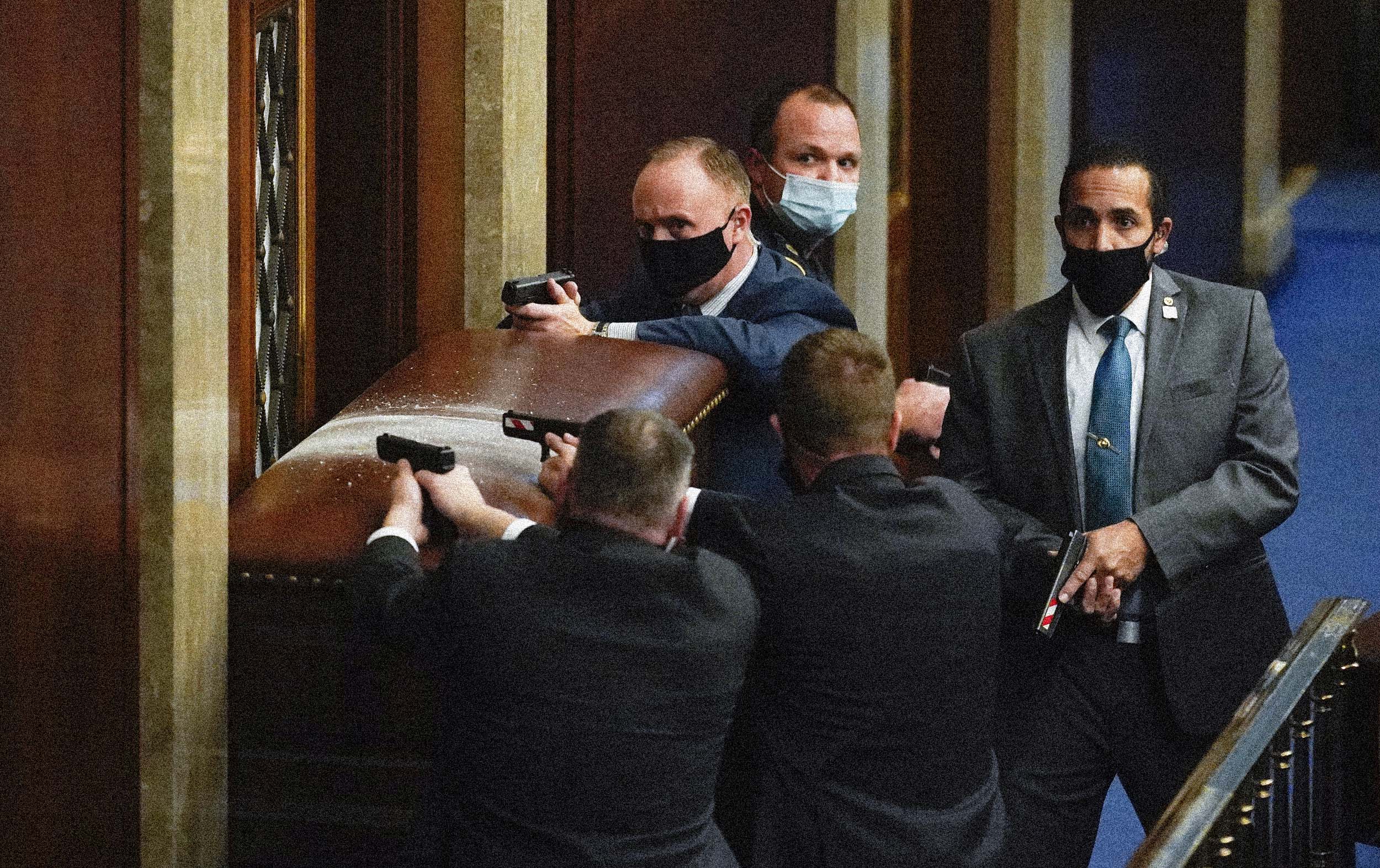 Capitol Police draw their guns near a barricaded door in the House Chamber. (Andrew Harnik / AP file)