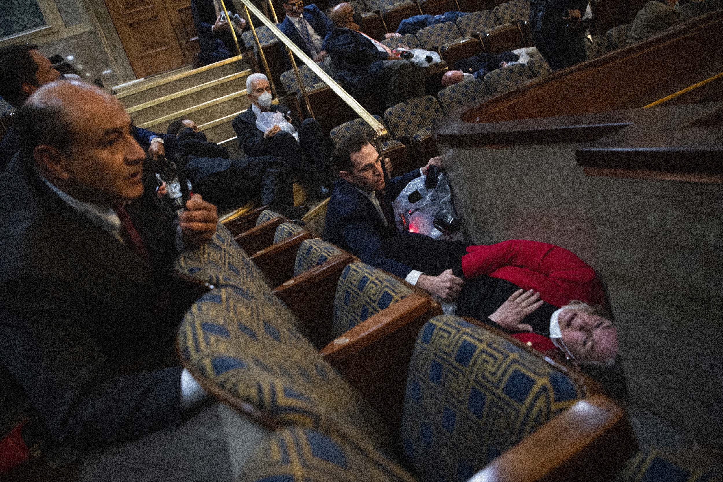Rep. Jason Crow, D-Colo., comforts Rep. Susan Wild, D-Pa., while taking cover as protesters enter the House Chamber at the Capitol. (Tom Williams / CQ-Roll Call via Getty Images file)