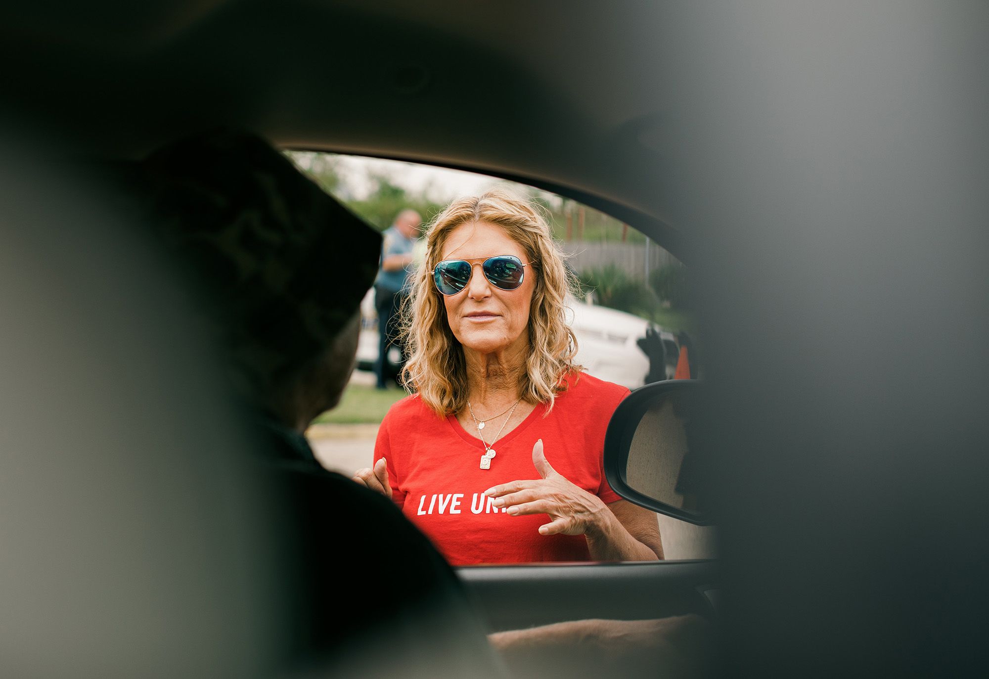 Denise Durel talks to a resident in line at the hurricane relief center. (Bryan Tarnowski for NBC News)