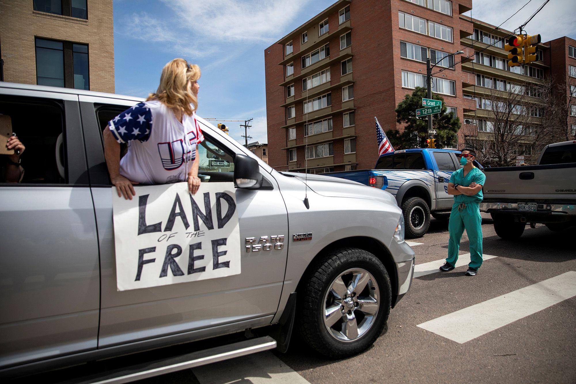 Health care workers stand in the street as a counter-protest to those demanding the stay-at-home order be lifted in Denver on April 19.