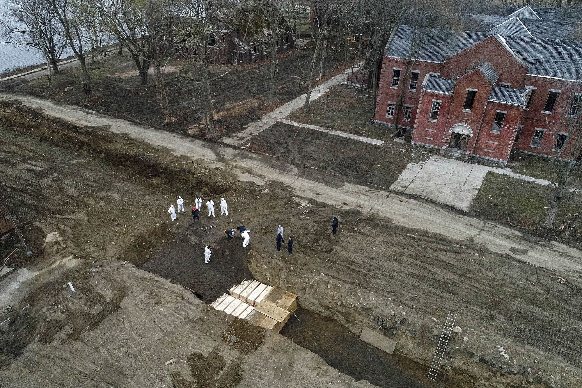 Workers bury bodies in a trench on Hart Island in New York City.