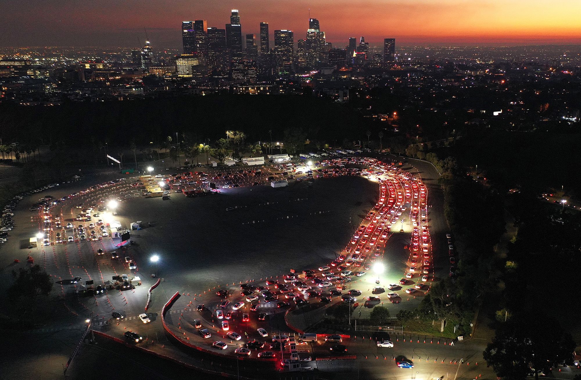 Cars line up at Dodger Stadium for Covid-19 testing as dusk falls over Los Angeles.