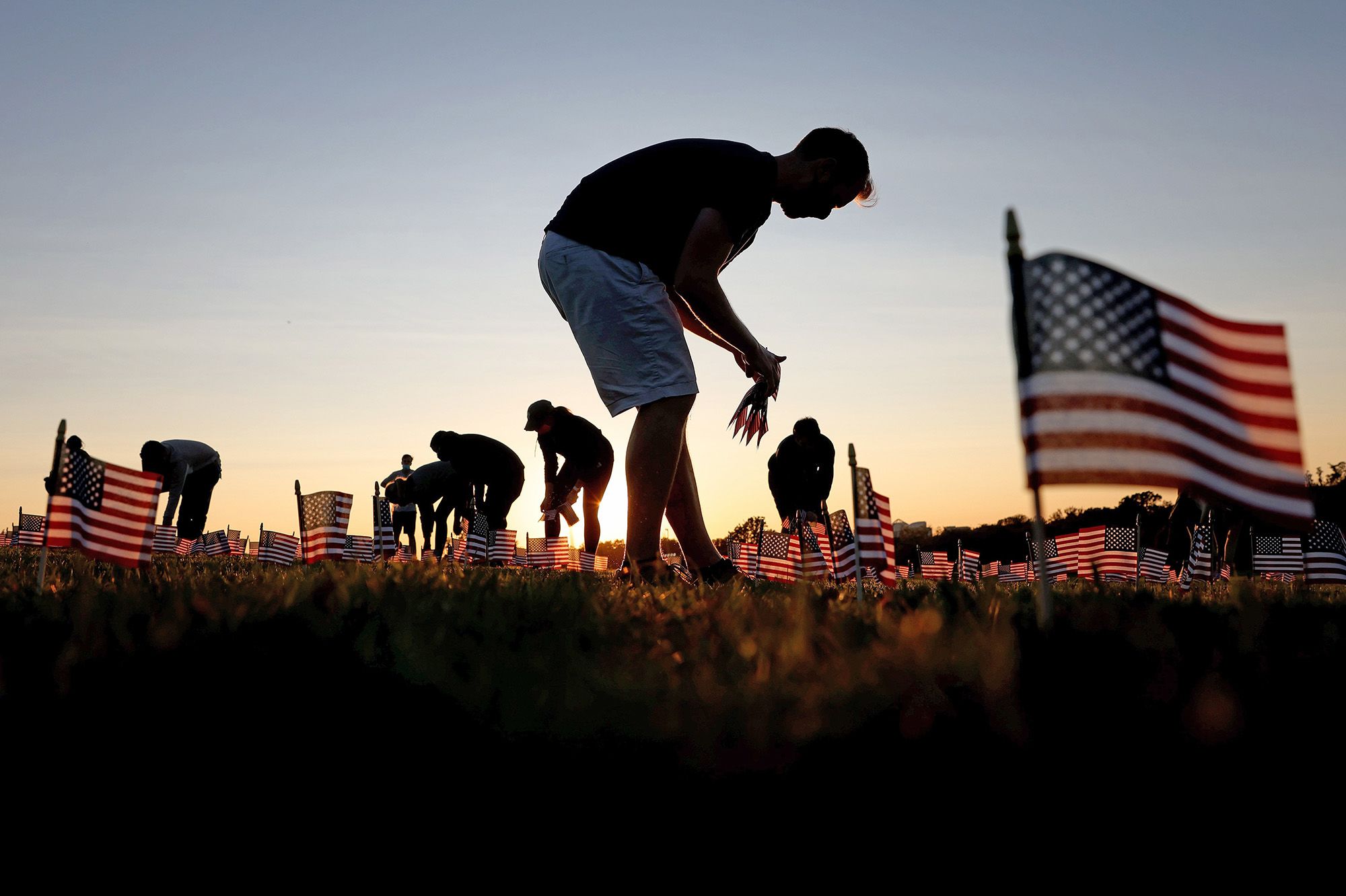 Volunteers with the COVID Memorial Project install 20,000 American flags on the National Mall to represent the 200,000 lives lost in the pandemic on Sept. 20.