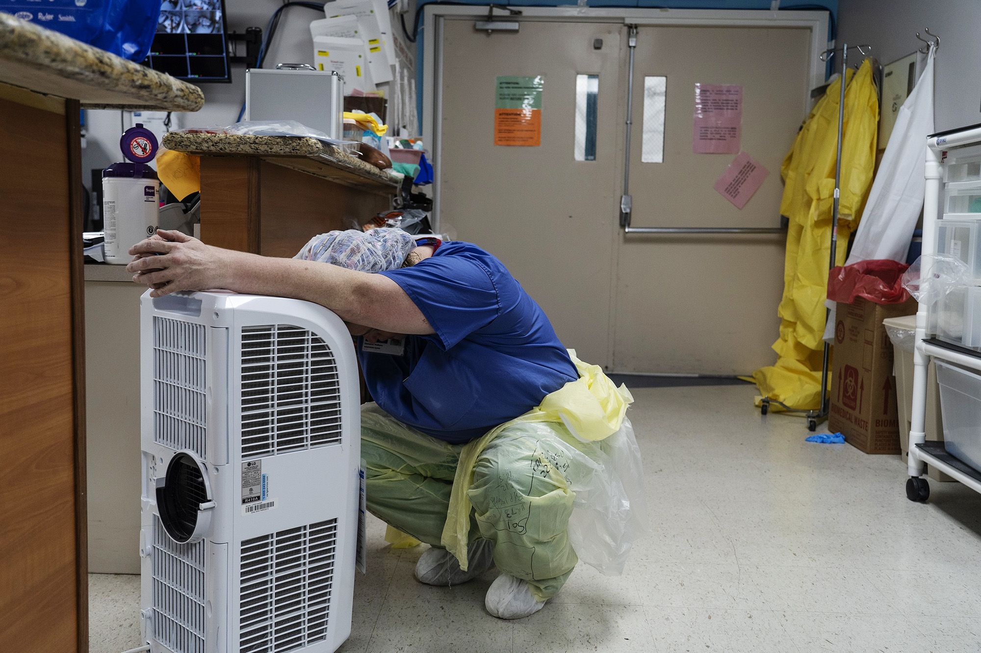 A staff member rests in front of a fan in the Covid-19 intensive care unit at the United Memorial Medical Center in Houston.