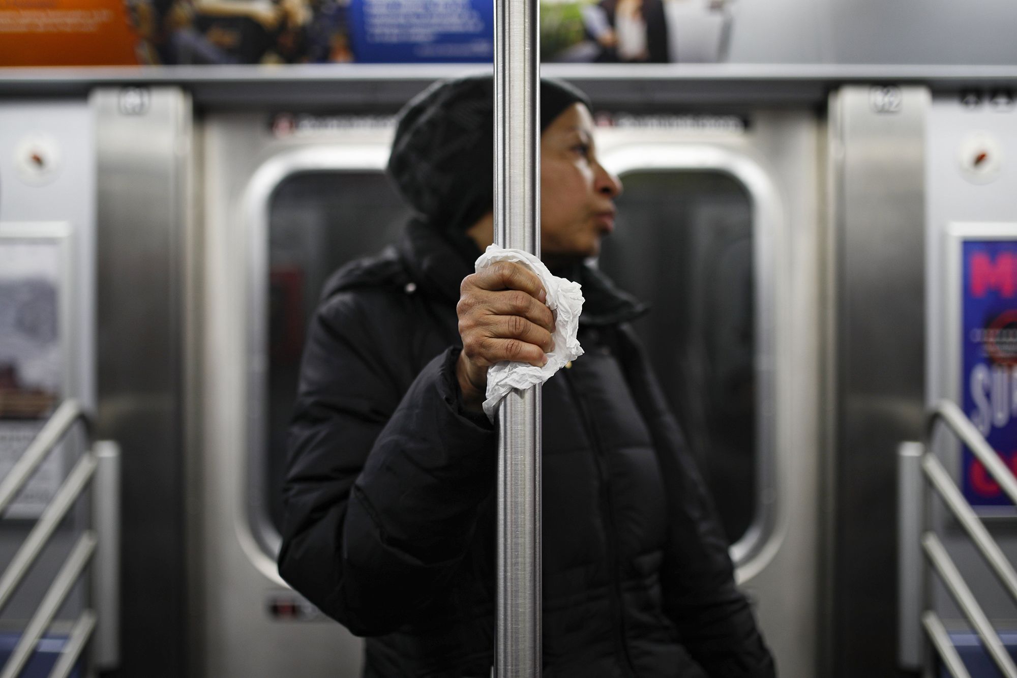 A subway passenger uses a tissue to hold onto a pole in New York.